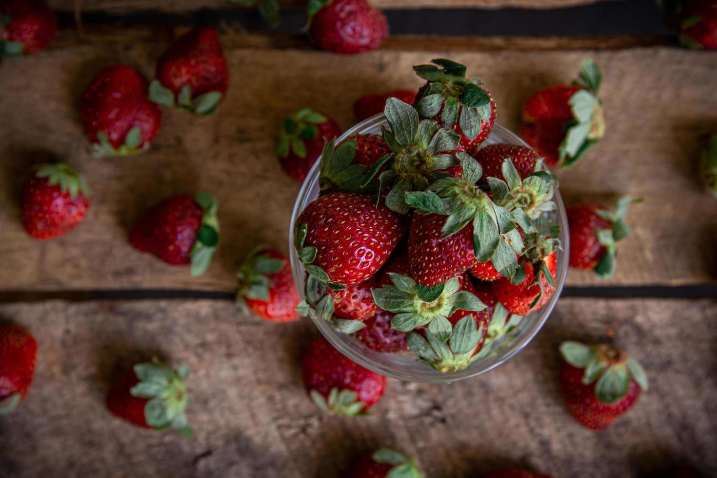 aardbeien in een glas en op een tafel foto