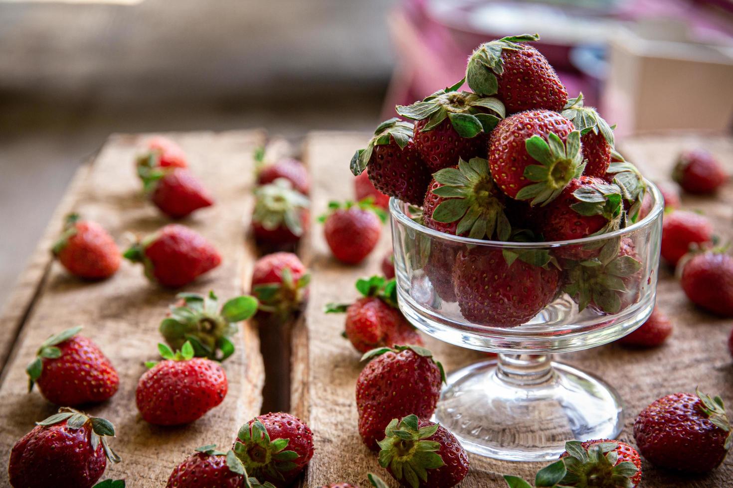 aardbeien in een glas en op een tafel foto