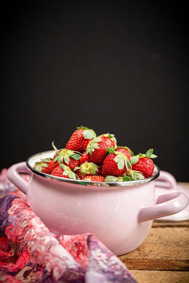 aardbeien in een kom op een houten tafel foto