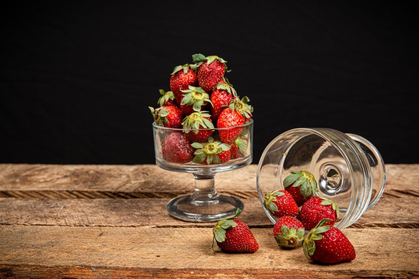 aardbeien in een glas op een houten tafel foto