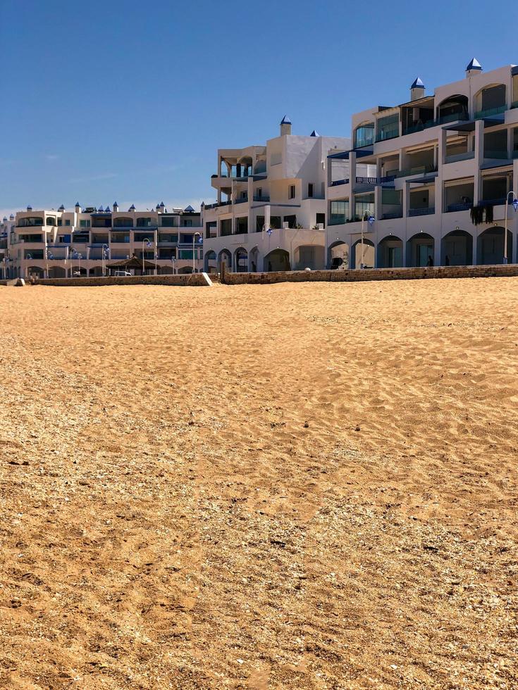 evenwichtig strandlandschap een harmonisch mengsel van zand, gebouwen, en natuurlijk schoonheid foto