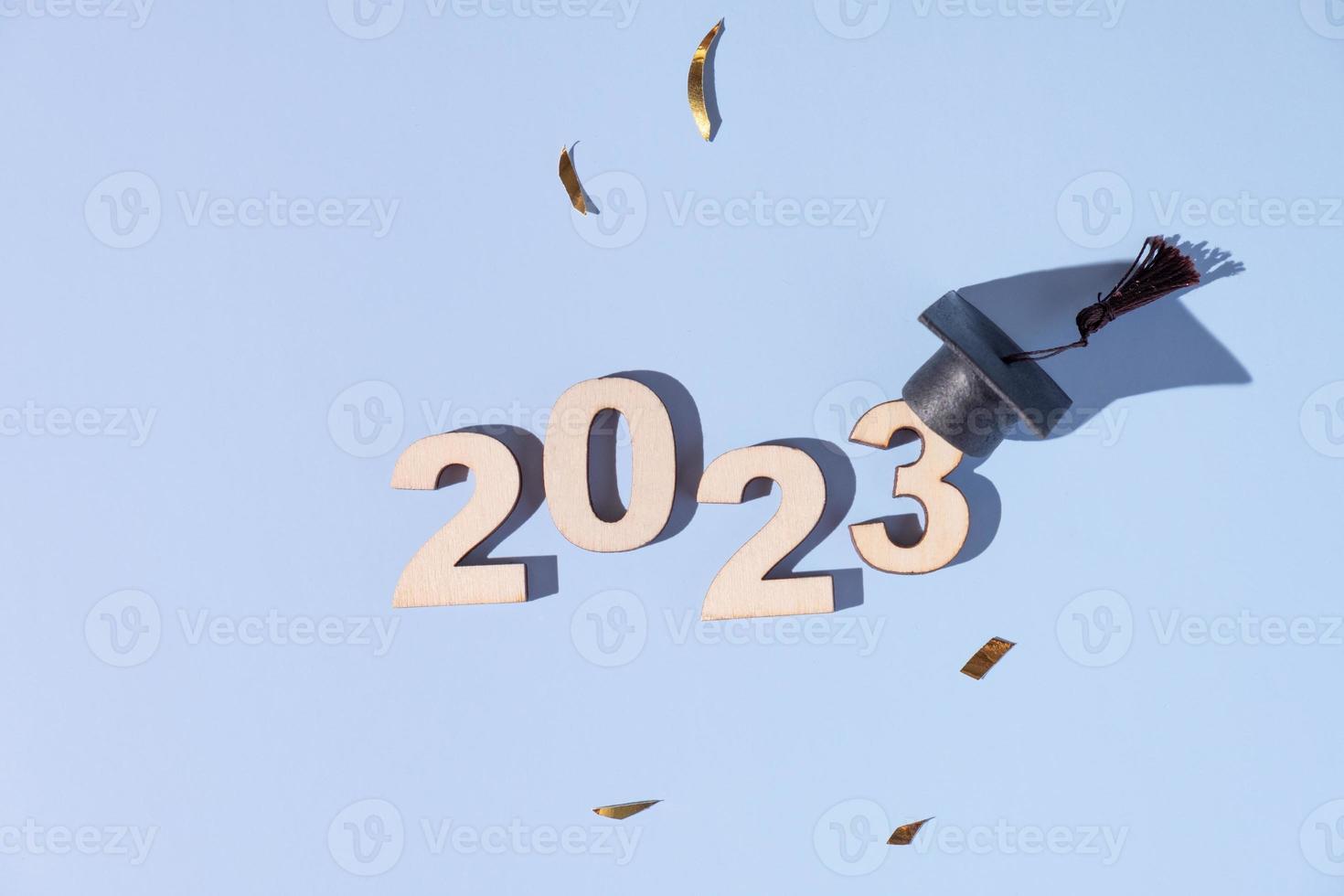 klasse van 2023 concept. getallen 2023 met zwart afgestudeerd pet Aan gekleurde achtergrond foto