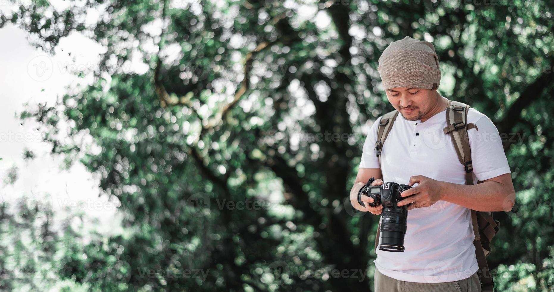 Aziatisch reiziger Mens controle een afbeelding Aan camera Bij de park foto