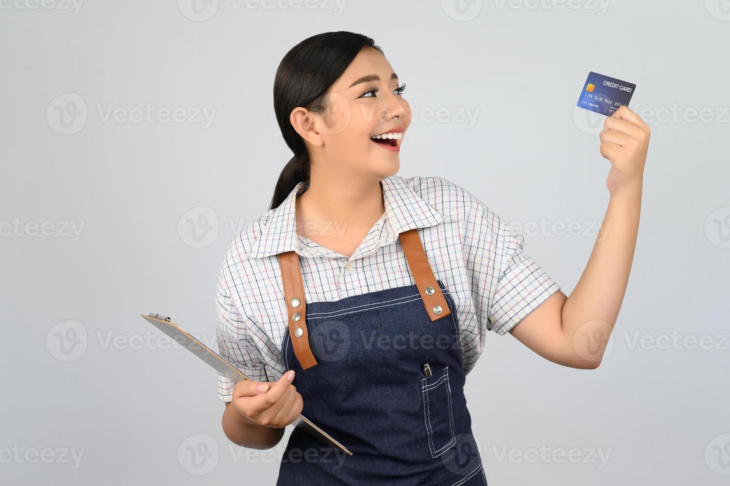 portret van jong Aziatisch vrouw in serveerster uniform houding met credit kaart foto