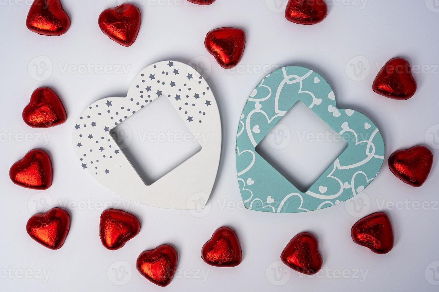 twee houten gekleurde leeg hartvormig foto kaders en veel van glimmend hartvormig snoepjes