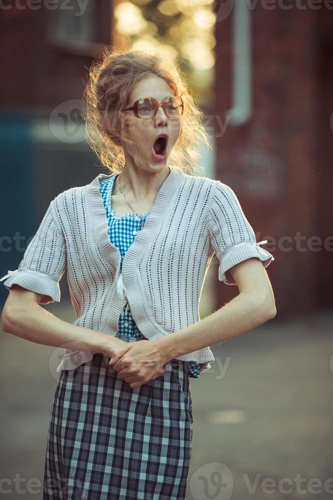 grappig gek meisje leerling in bril en een wijnoogst jurk foto