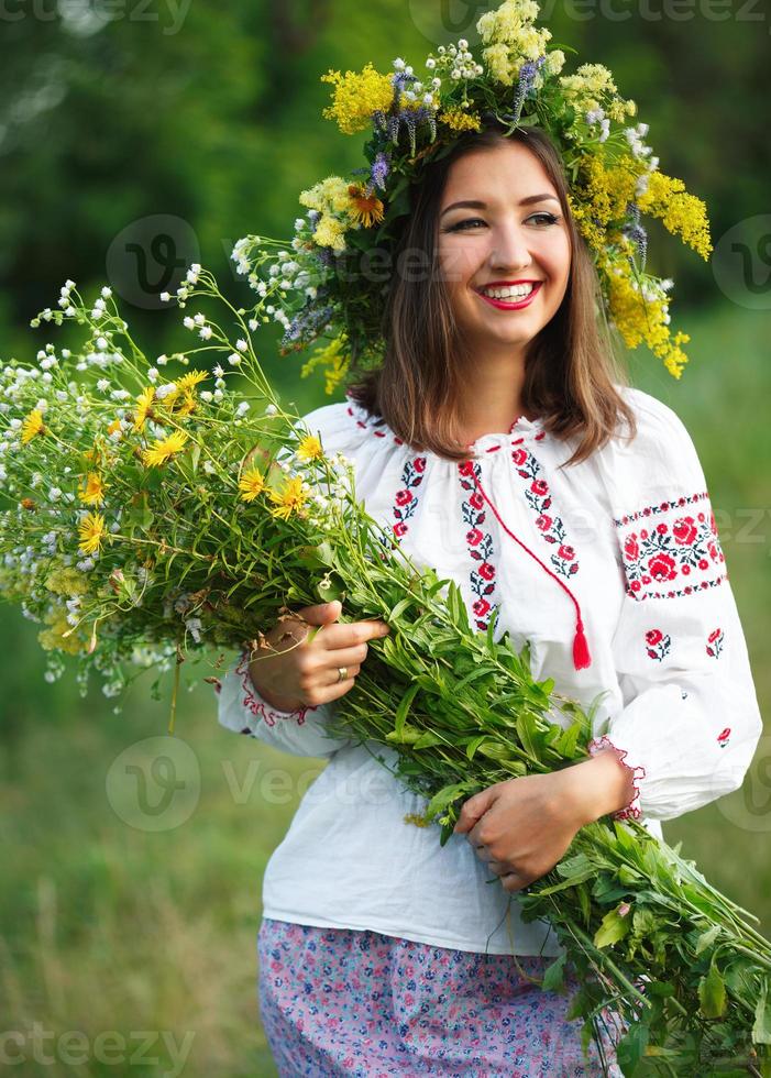 jong mooi glimlachen meisje in oekraïens kostuum met een krans Aan zijn hoofd foto