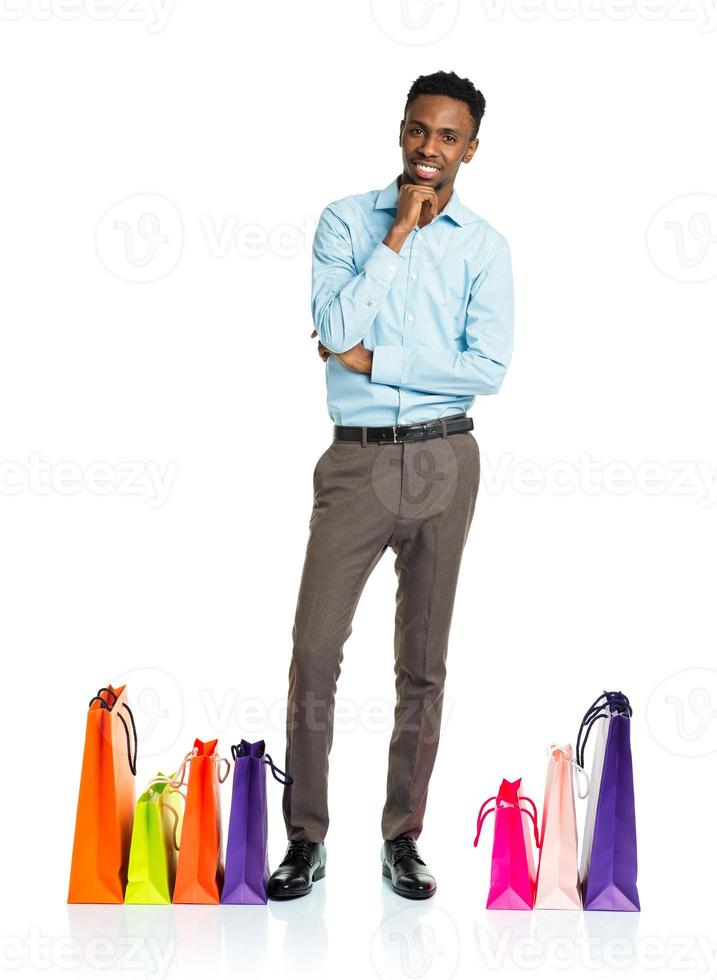 gelukkig Afrikaanse Amerikaans Mens met boodschappen doen Tassen Aan wit achtergrond foto