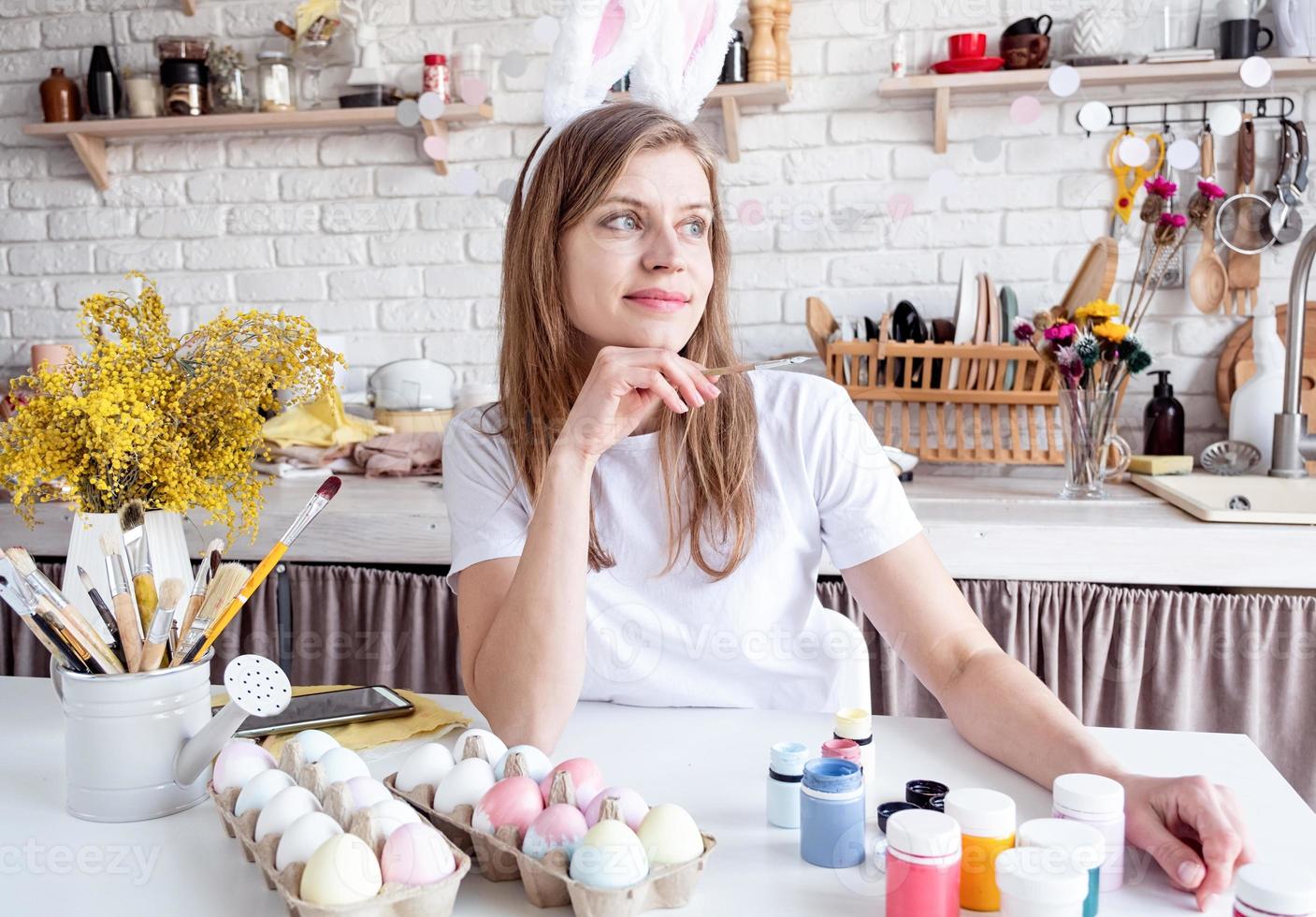 portret van een gelukkig vrouw in konijn oren Aan wit steen muur achtergrond foto