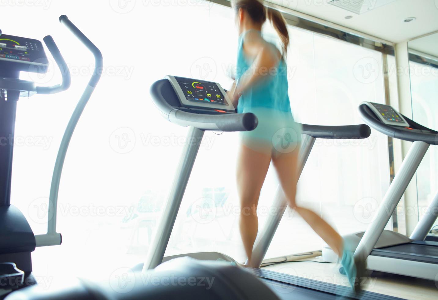 vrouw rennen Aan loopband in Sportschool foto