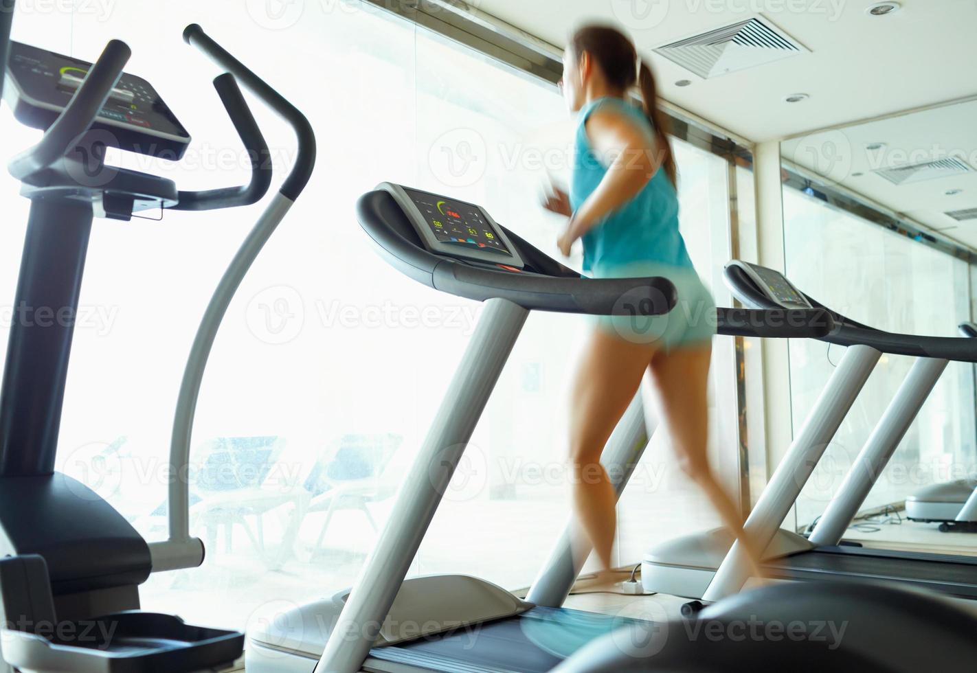 vrouw rennen Aan loopband in Sportschool foto