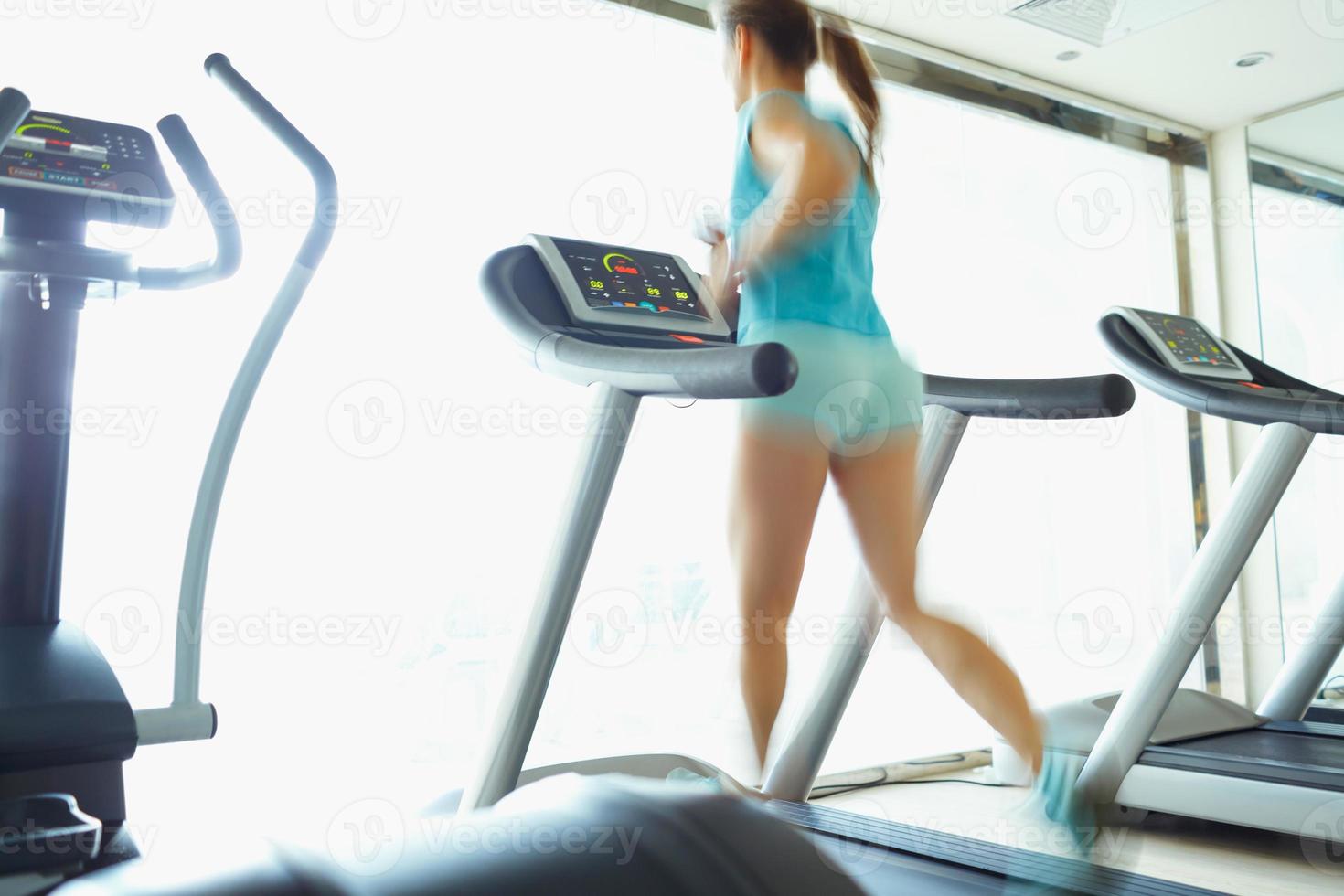 vrouw rennen Aan loopband in Sportschool foto