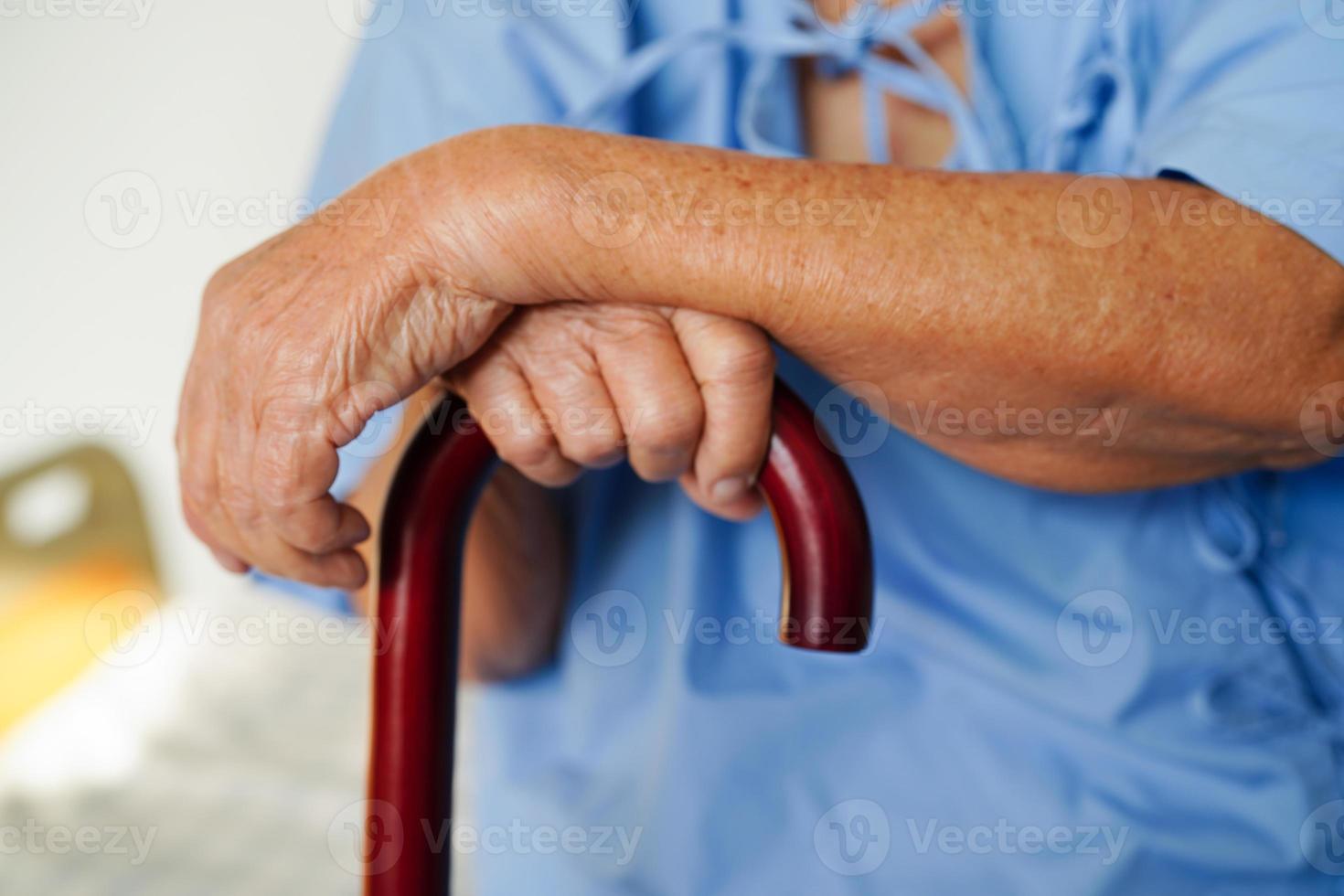 Aziatisch ouderen onbekwaamheid vrouw geduldig Holding wandelen stok in gerimpeld hand- Bij ziekenhuis. foto