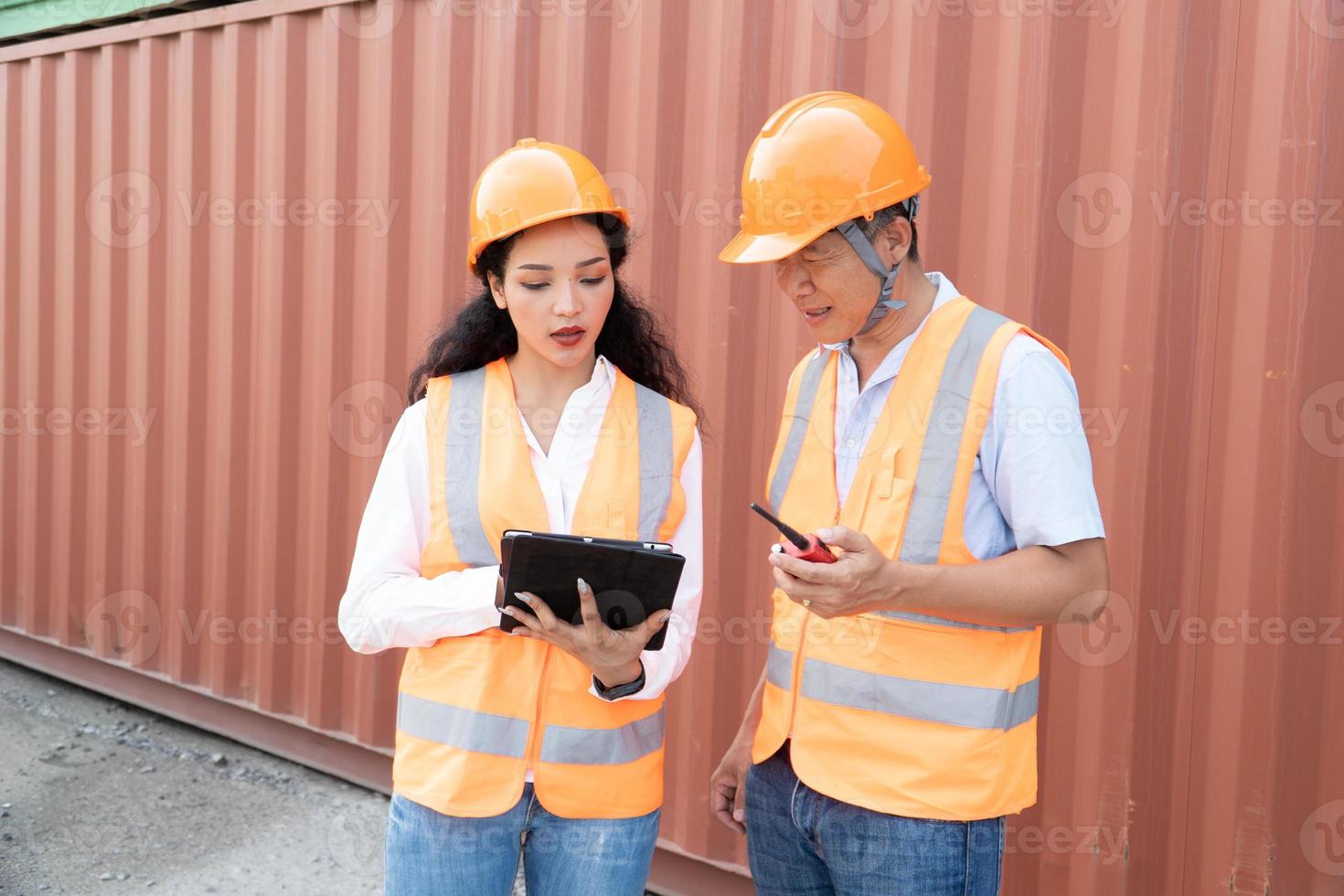 vrouw Aziatisch ingenieur en voorman ingenieur bezig met laden containers van lading schip voor exporteren. Daar is een houder in de achtergrond. foto