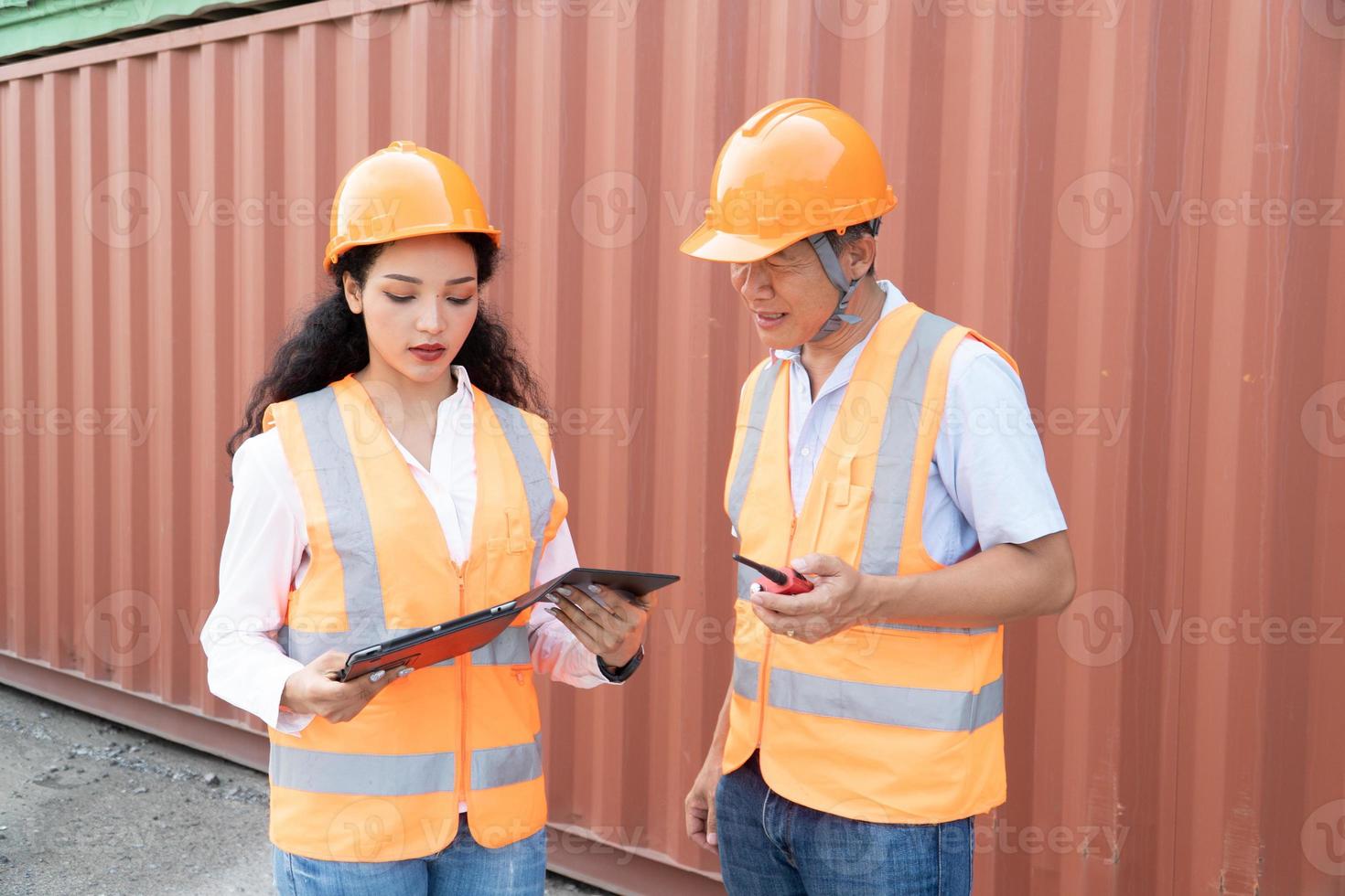 vrouw Aziatisch ingenieur en voorman ingenieur bezig met laden containers van lading schip voor exporteren. Daar is een houder in de achtergrond. foto