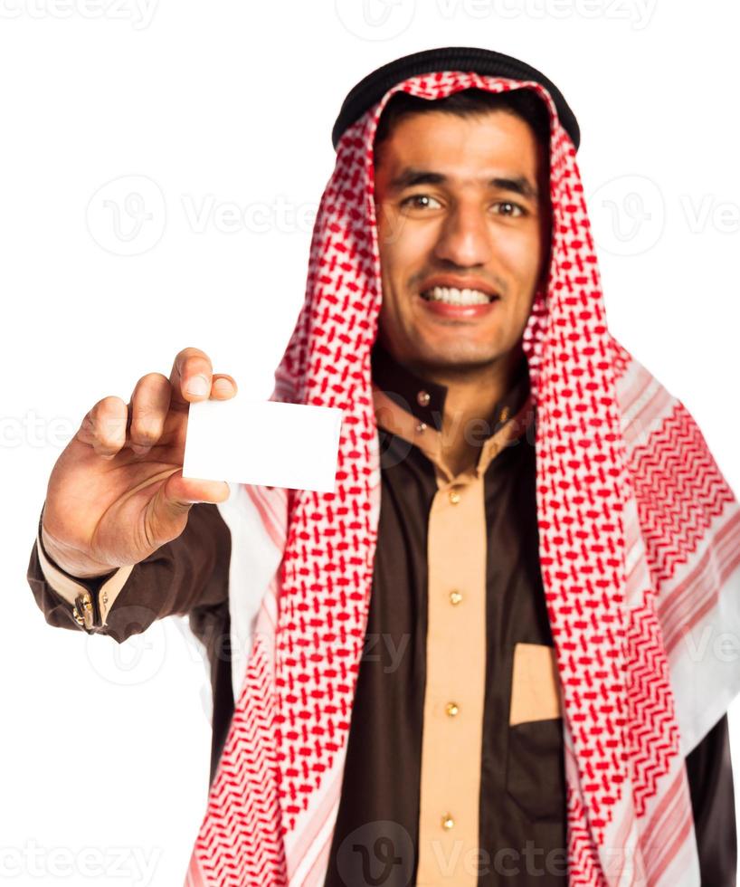 jong glimlachen Arabisch tonen bedrijf kaart in hand- geïsoleerd Aan wit foto