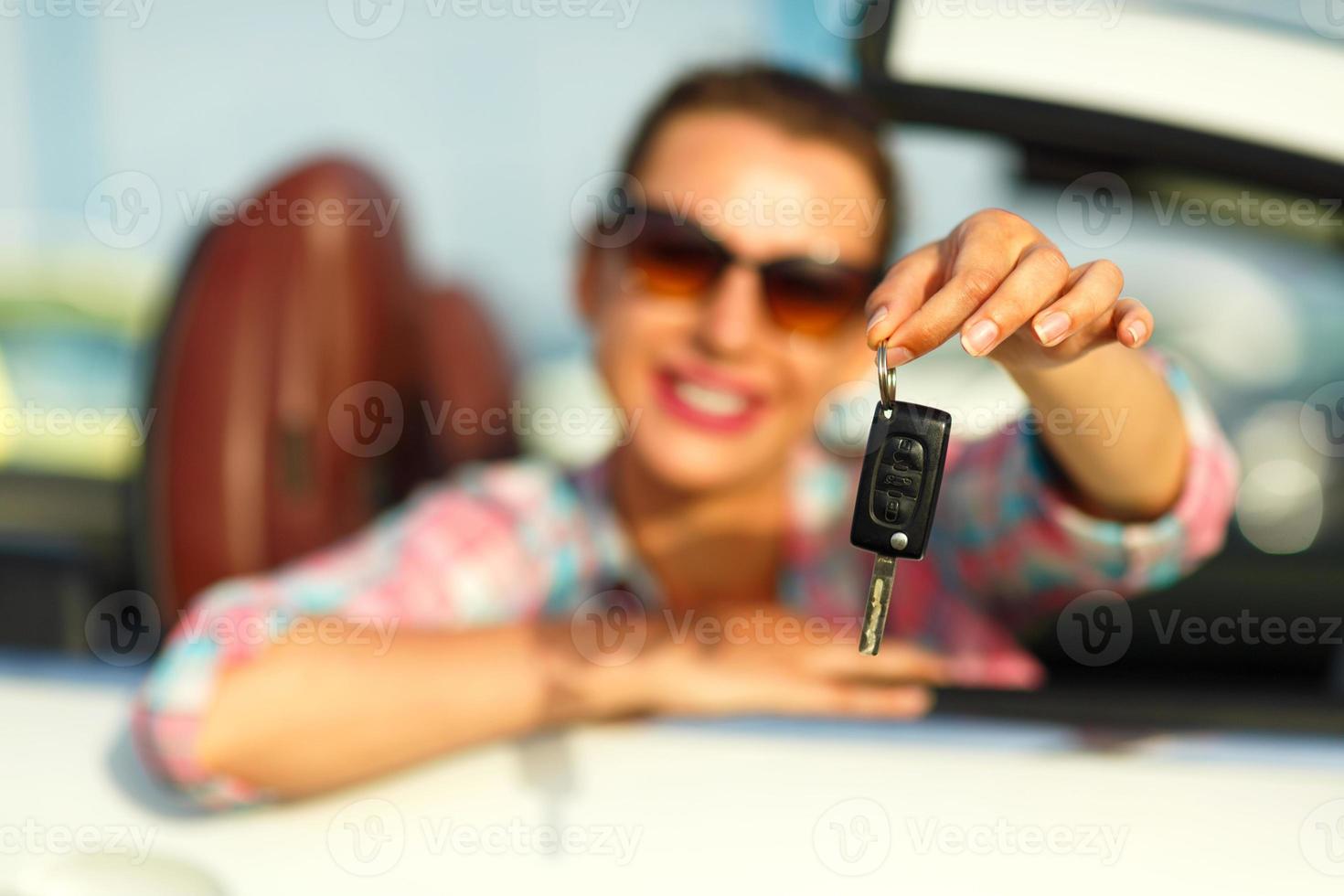 vrouw zittend in een converteerbaar auto met de sleutels in hand- - concept van buying een gebruikt auto of een verhuur auto foto