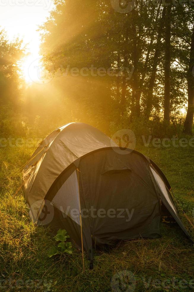 toerist tenten Aan oever van de rivier Bij zonsopkomst foto