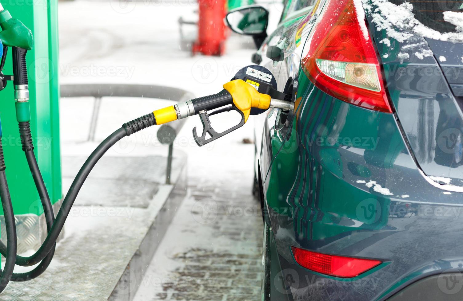 auto tanken Aan een benzine station in winter foto