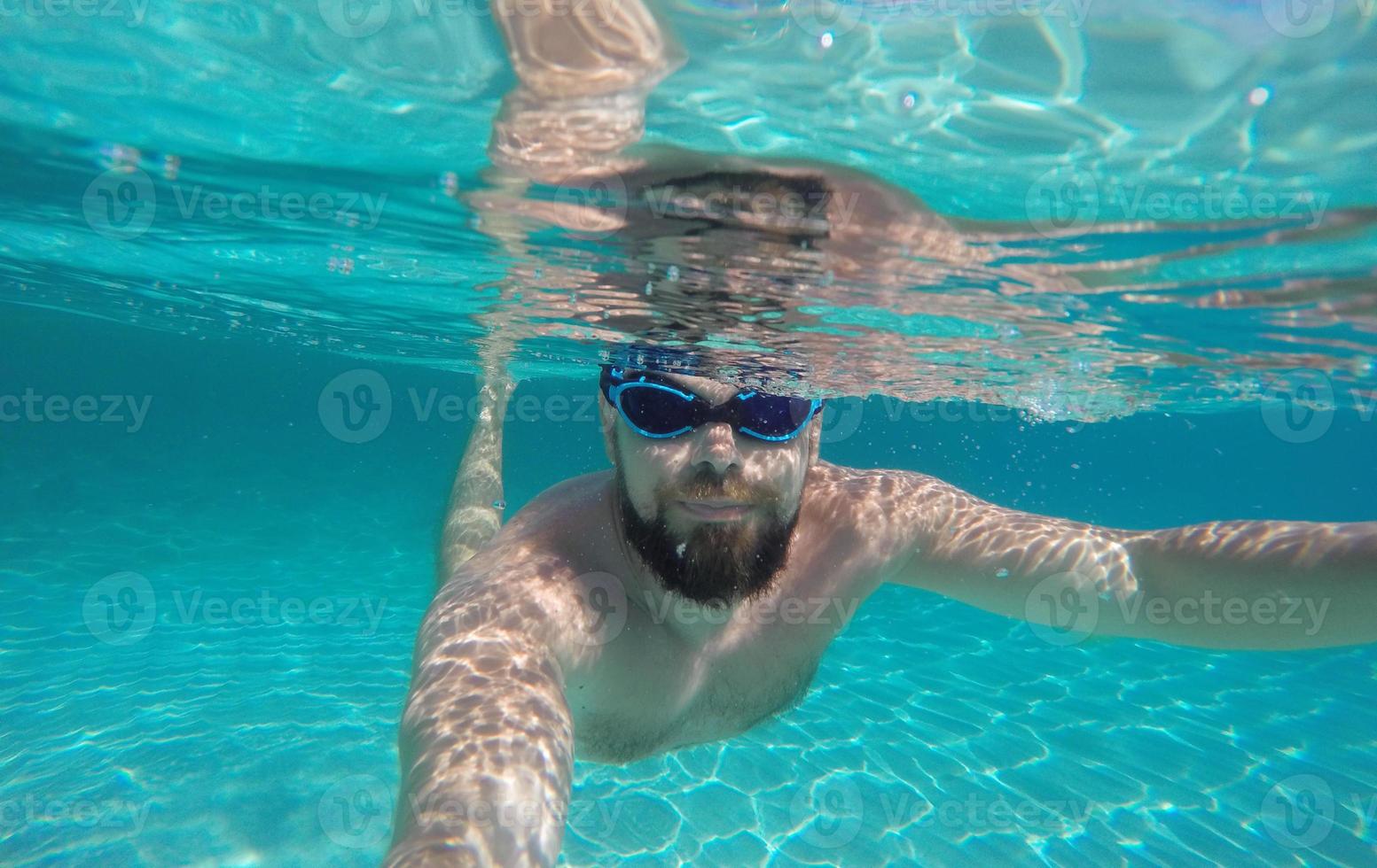 Mens aan het doen onderwater- selfie schot in diep blauw zee foto