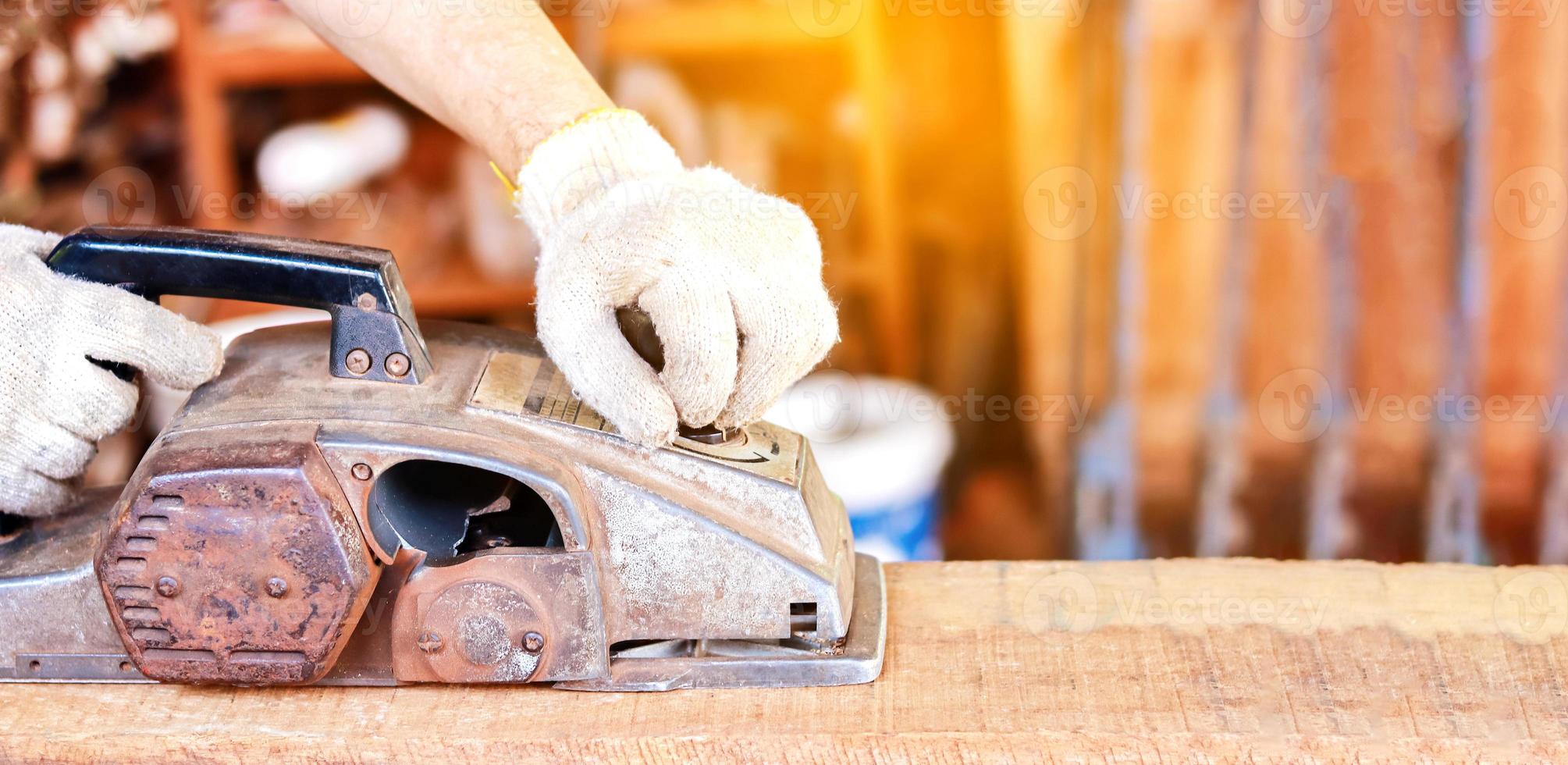 hand werken met met elektrische schaafmachine buitenshuis foto