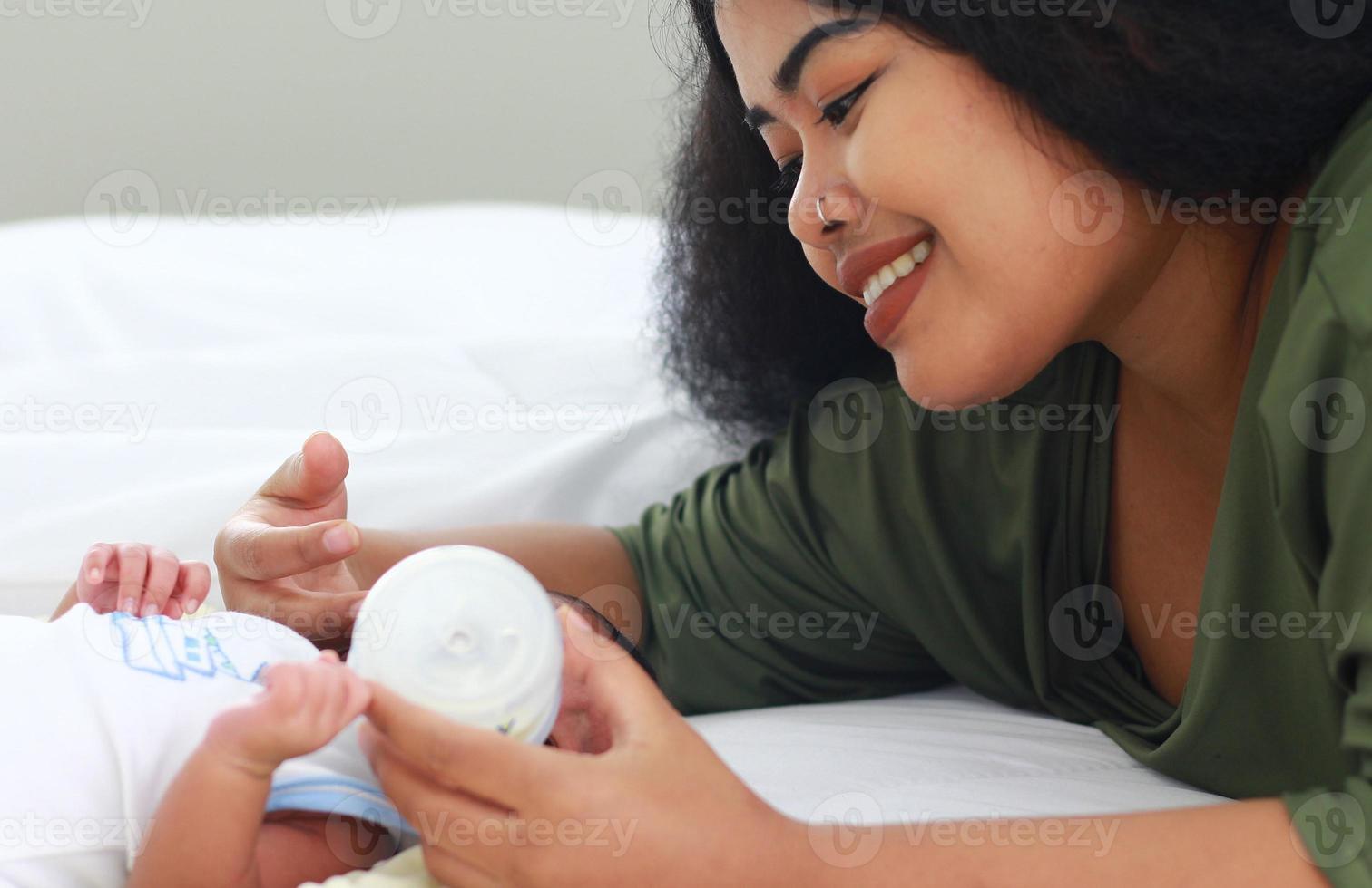 moeder geniet van het voeden van haar pasgeboren zoon foto