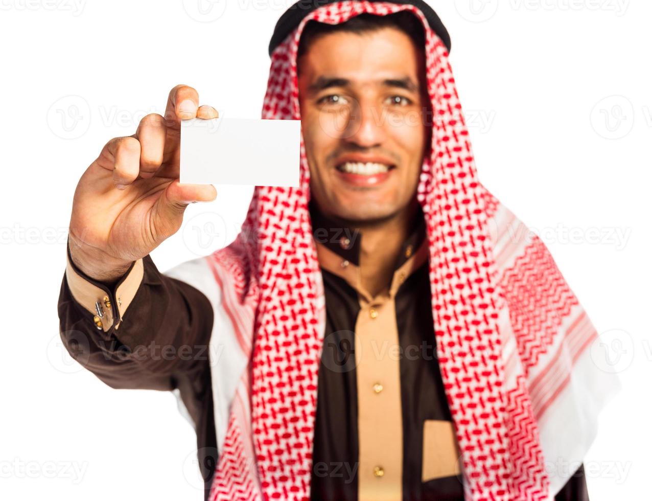 jong glimlachen Arabisch tonen bedrijf kaart in hand- geïsoleerd Aan wit foto