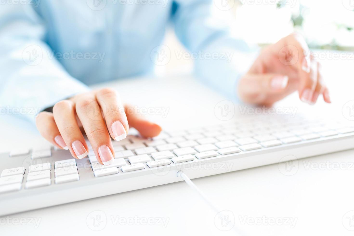 vrouw kantoor arbeider typen Aan de toetsenbord foto