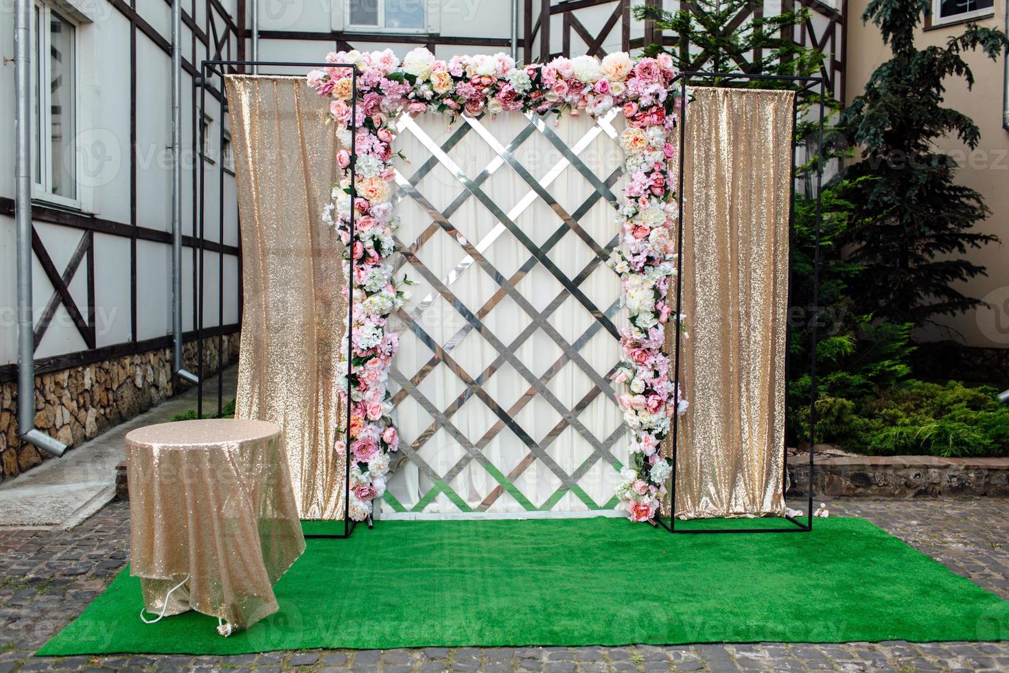 bruiloft decor. de bruiloft ceremonie Oppervlakte in de achtertuin is versierd met wit en roze bloemen regelingen en goud kleding foto