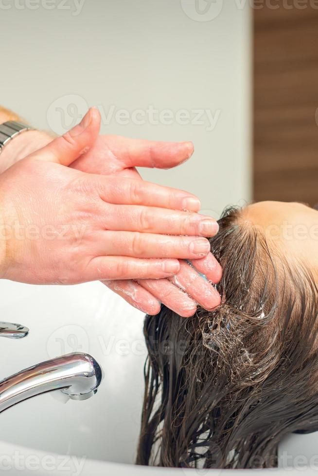 jong vrouw het wassen haar haar- foto