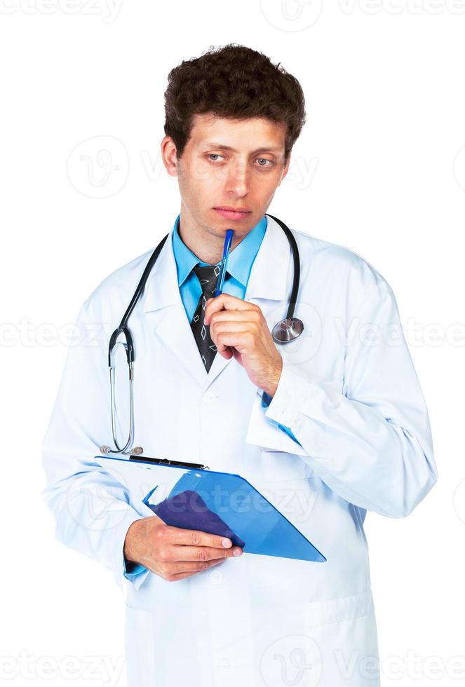 portret van beraadslagend jong mannetje dokter schrijven Aan een patiënten medisch tabel Aan wit foto