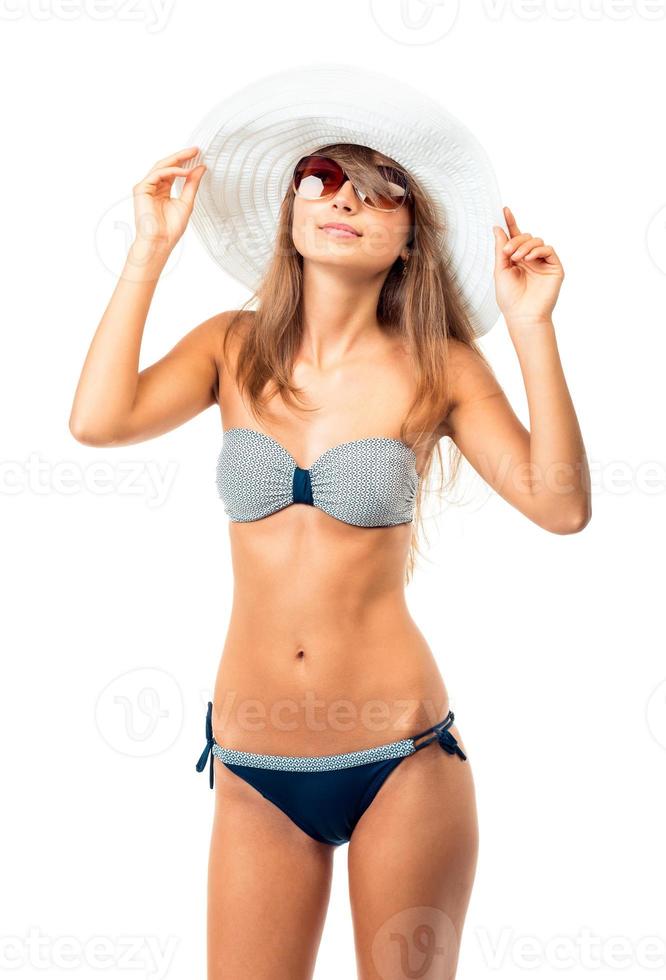 portret van een mooi jong vrouw poseren in bikini, hoed en zonnebril Aan wit foto