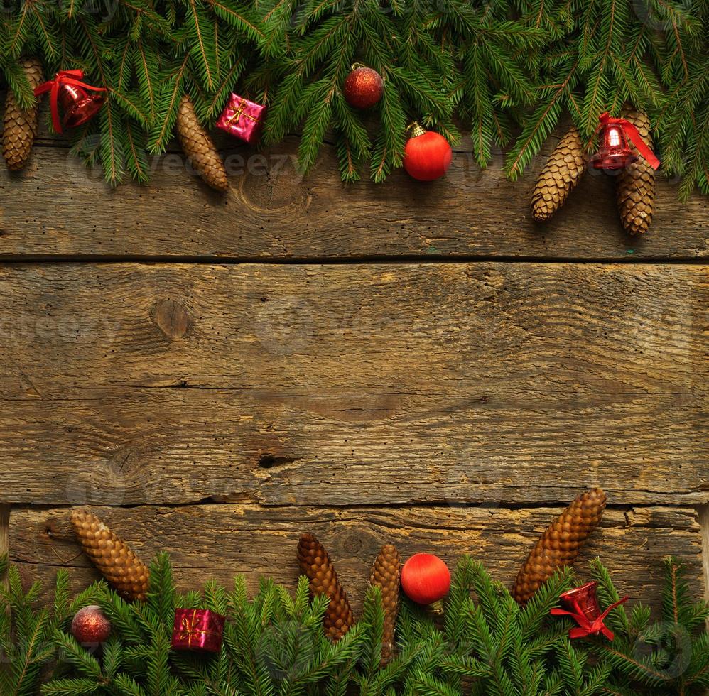 Kerstmis grens met Spar boom takken, kegels en Kerstmis decoraties Aan houten borden klaar voor uw ontwerp foto