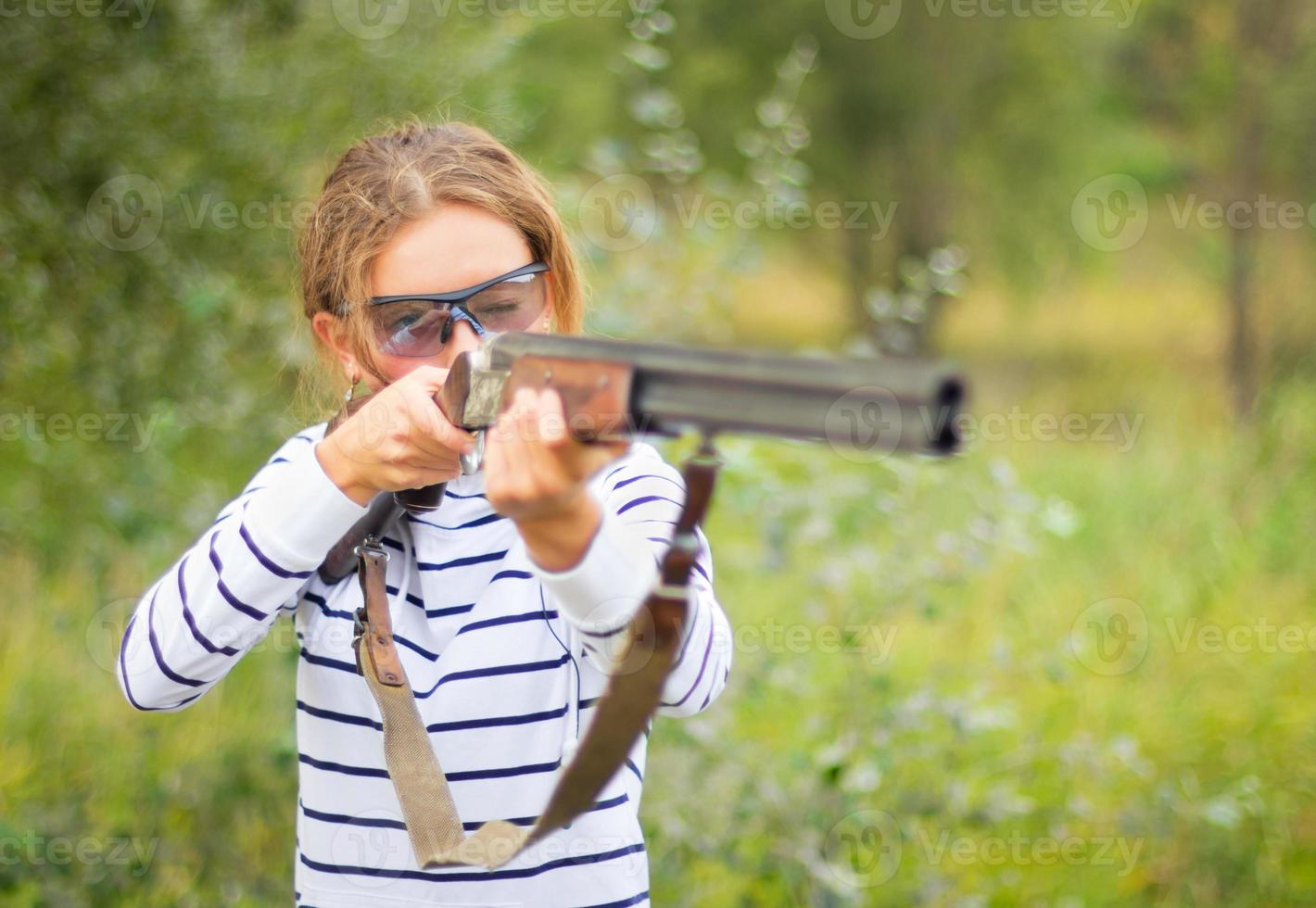 een jong meisje met een geweer voor val het schieten foto