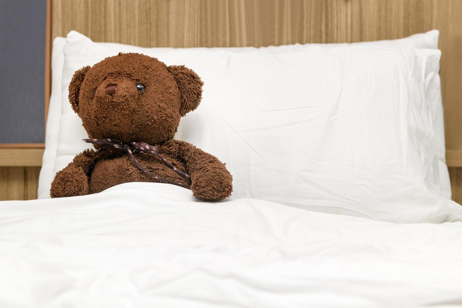 eenzaam teddy beer aan het liegen Aan de bed. concept over aan het wachten voor iemand foto