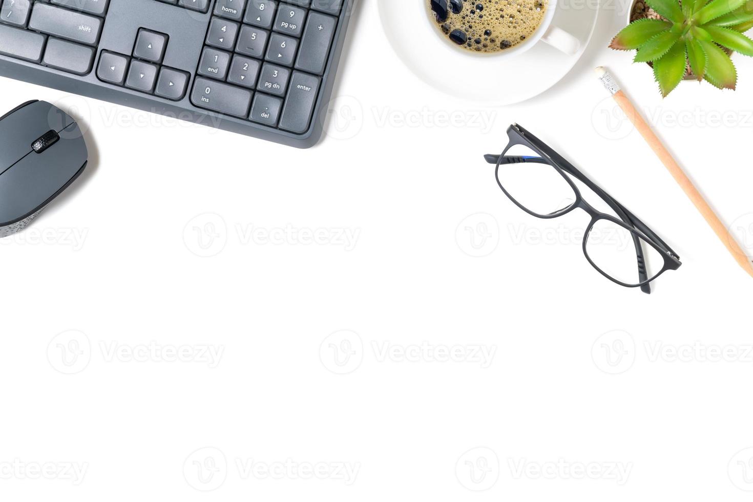 wit kantoor bureau tafel, computer toetsenbord en andere kantoor benodigdheden met zwart koffie. foto