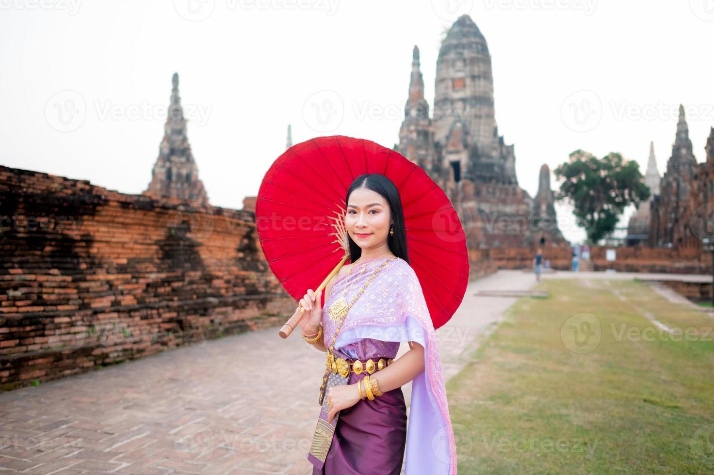 mooi Thais meisje in traditioneel jurk kostuum rood paraplu net zo Thais tempel waar is de openbaar plaats, Thais vrouw in traditioneel kostuum van Thailand. foto