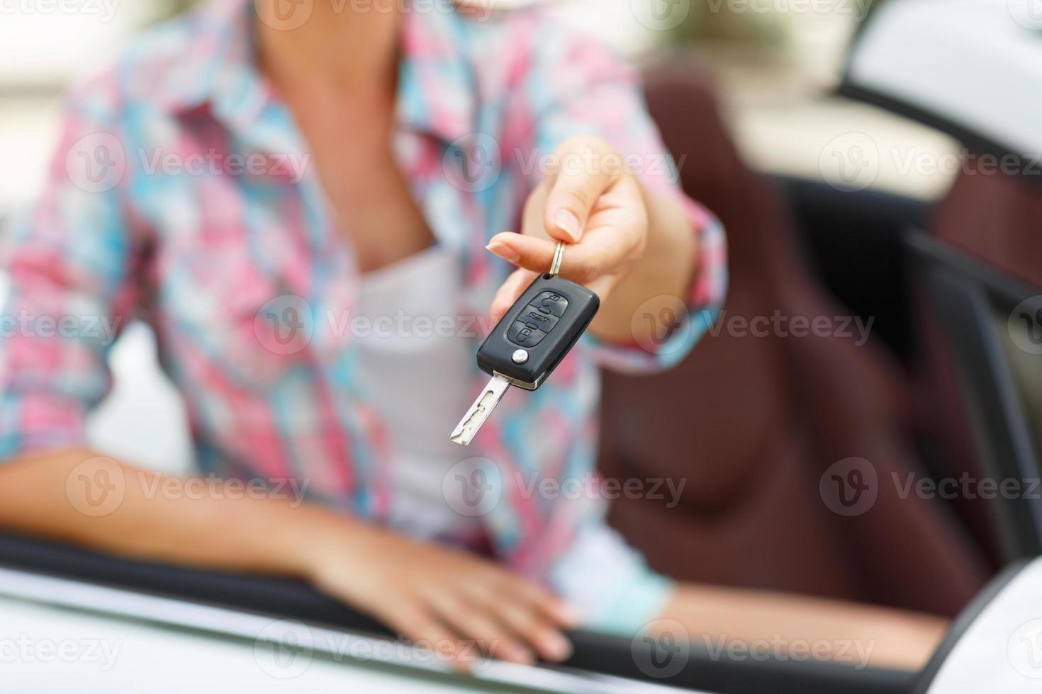 vrouw staand in de buurt converteerbaar met sleutels in hand- - concept van buying een gebruikt auto of een verhuur auto foto