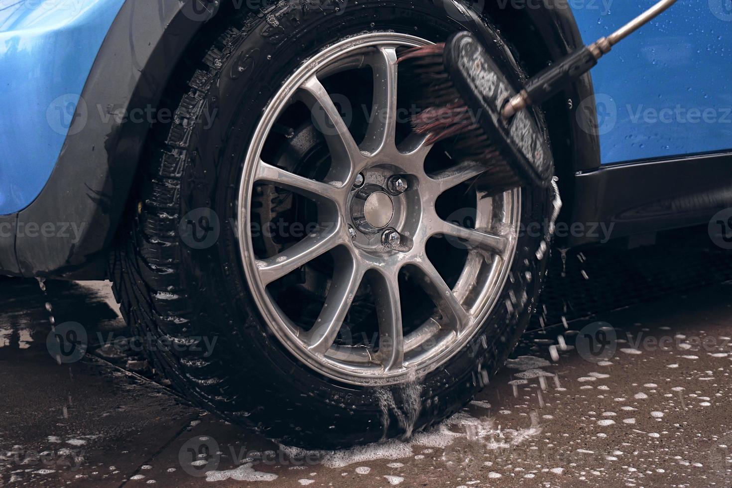hand- wassen met zeep, roze schuim Aan de lichaam. auto het wassen met hoog druk water. foto