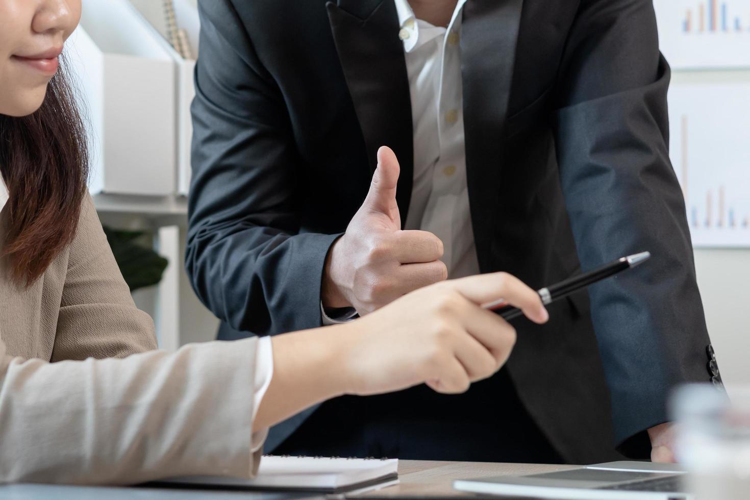 feliciteren, vertrouwen twee collega Aziatisch zakenman, vrouw aanmoedigen personeel voor gedaan uitstekend werk. baas tonen duimen omhoog naar Doen heel mooi zo functie. leiderschap van team steun. vertrouwen van leidinggevende. foto