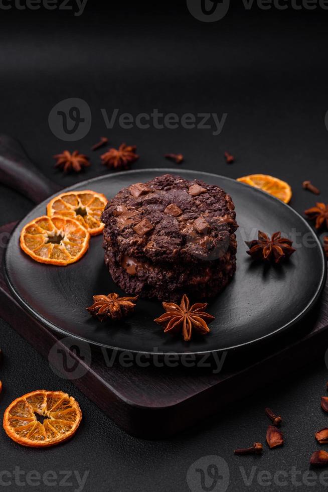 heerlijk vers havermout ronde koekjes met chocola Aan een zwart keramisch bord foto
