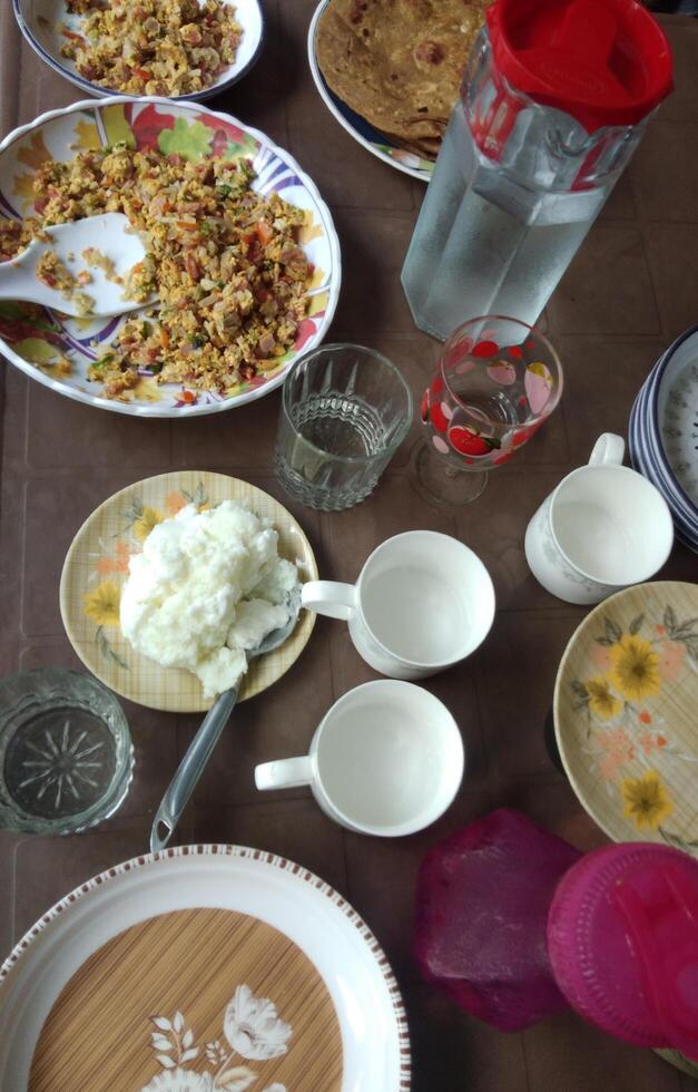 Indisch en Pakistaans ontbijt combo met paratha, ei amlette en thee Aan ontbijt tafel foto