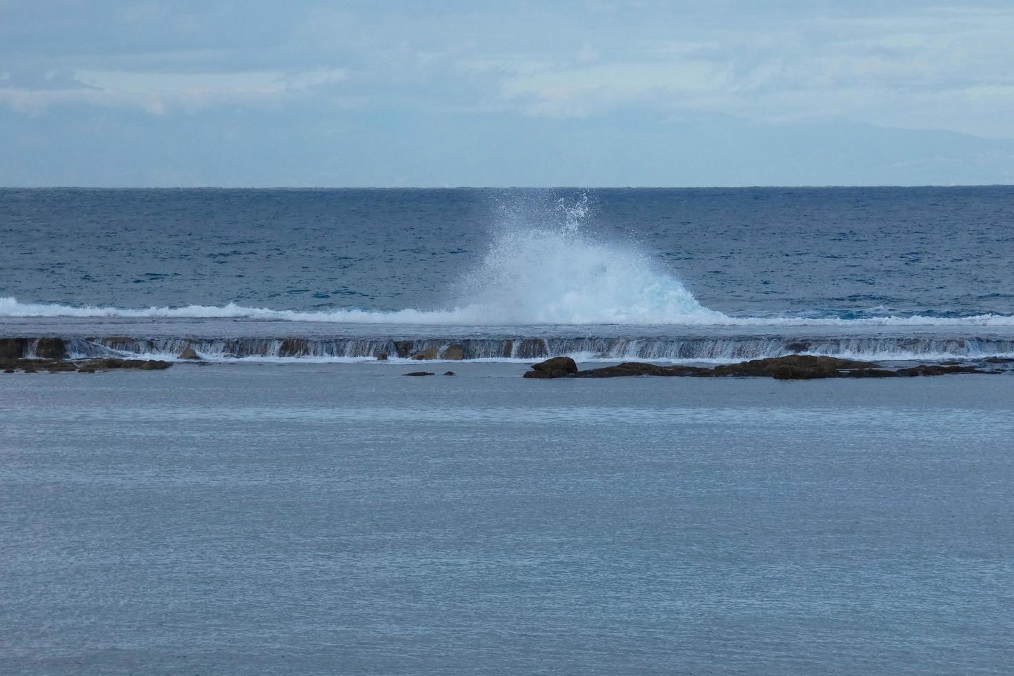 groot golven crashen tegen de rotsen in de oceaan foto