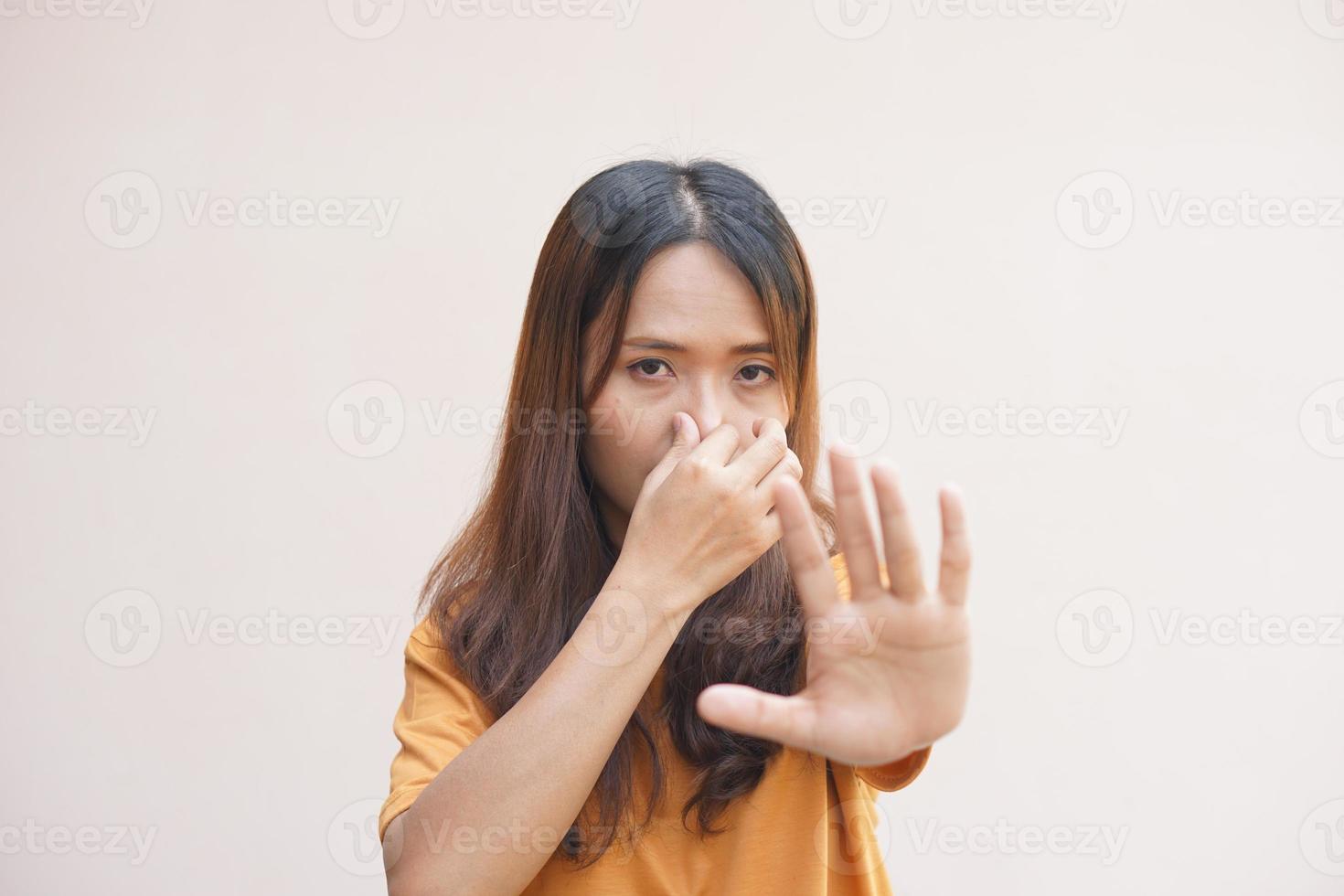 Aziatisch vrouw aan het bedekken haar neus- met haar handen ten gevolge naar geur foto