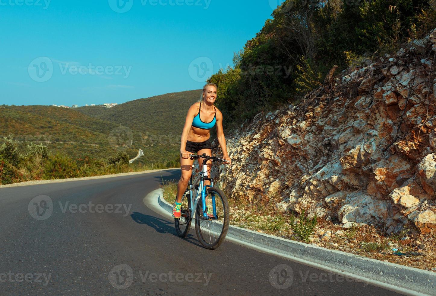 vrouw fietser rijden een fiets Aan een berg weg foto