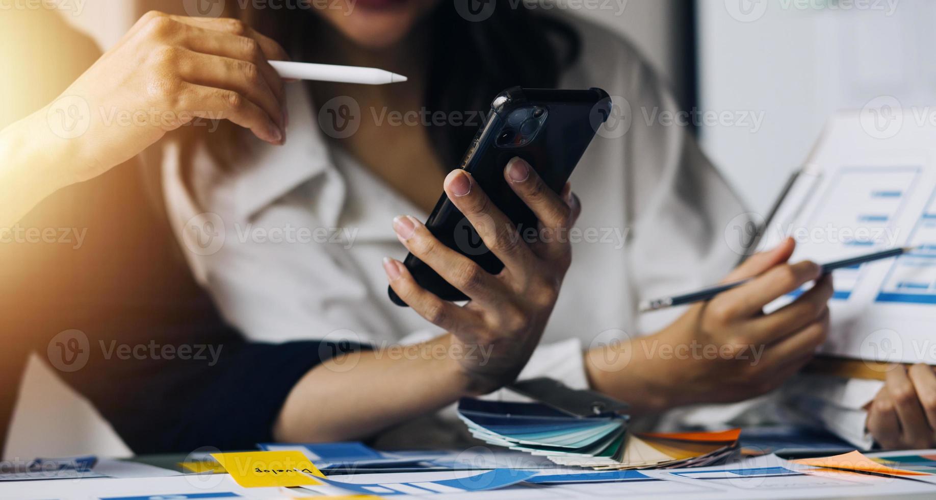 dichtbij omhoog ux ontwikkelaar en ui ontwerper brainstorming over mobiel app koppel wireframe ontwerp Aan tafel met klant breif en kleur code Bij modern kantoor.creatief digitaal ontwikkeling agentschap foto