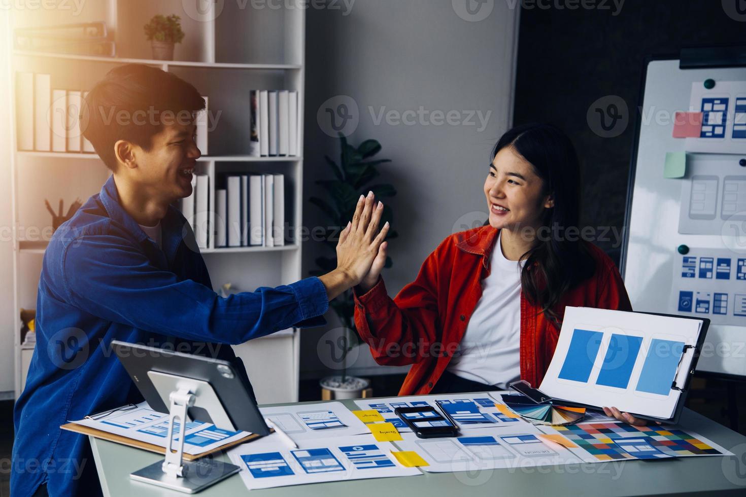 dichtbij omhoog ux ontwikkelaar en ui ontwerper brainstorming over mobiel app koppel wireframe ontwerp Aan tafel met klant breif en kleur code Bij modern kantoor.creatief digitaal ontwikkeling agentschap foto