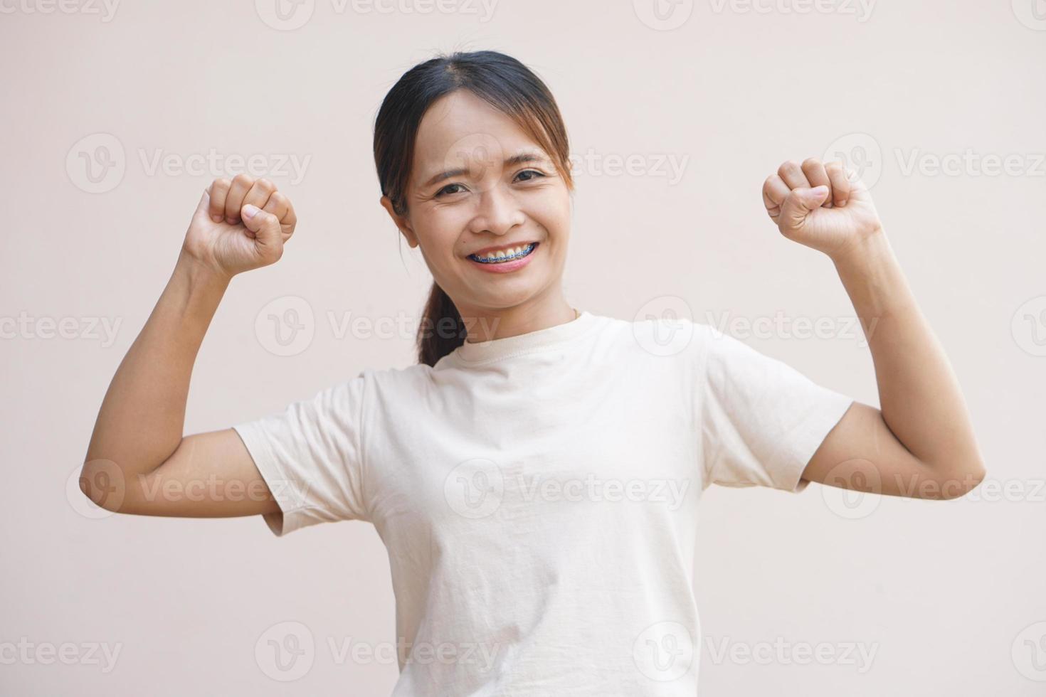 Aziatisch vrouw balanceren haar vuisten zelfverzekerd, verheugd foto