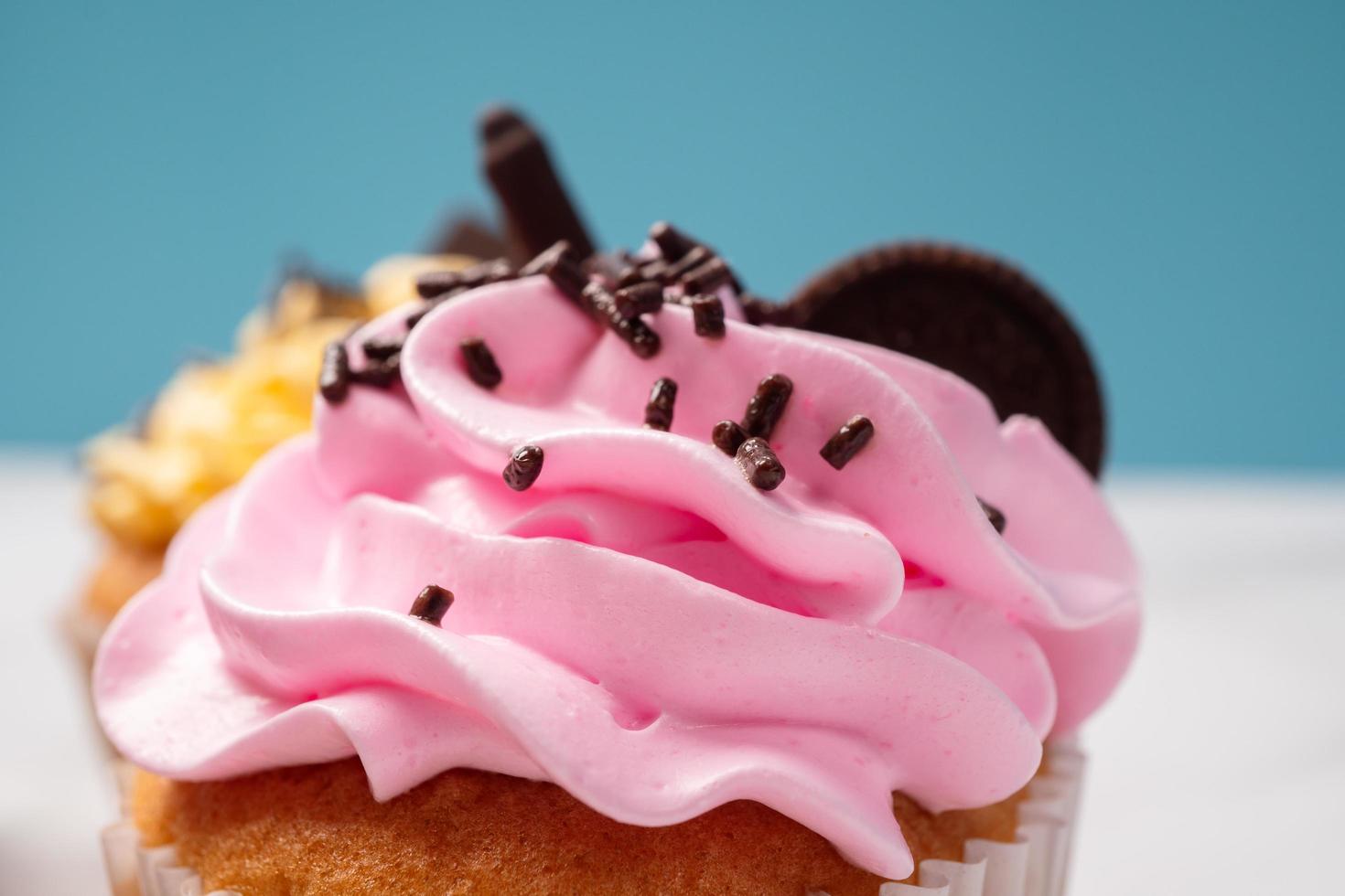 heerlijke zelfgemaakte cupcakes met kleurrijke slagroom en topping met snoep en chocoladekoekjes. zelfgemaakte herfstvakantie dessert foto