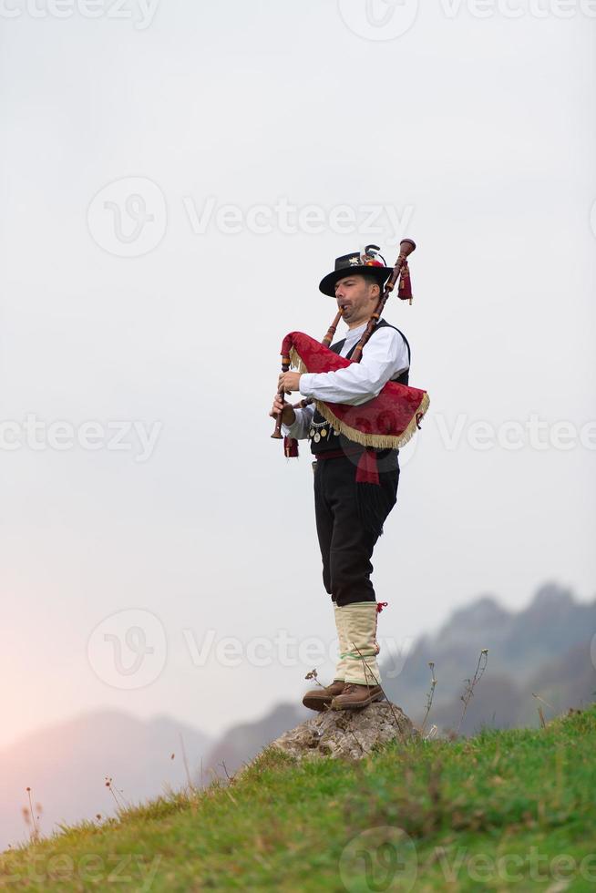 man met behulp van een doedelzak, een traditioneel instrument uit Noord-Italië vergelijkbaar met de Schotse instrumenten en Galicische gaita foto